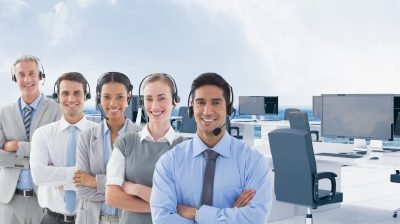Digital composite image of call center executive wearing headphones and standing with arms crossed